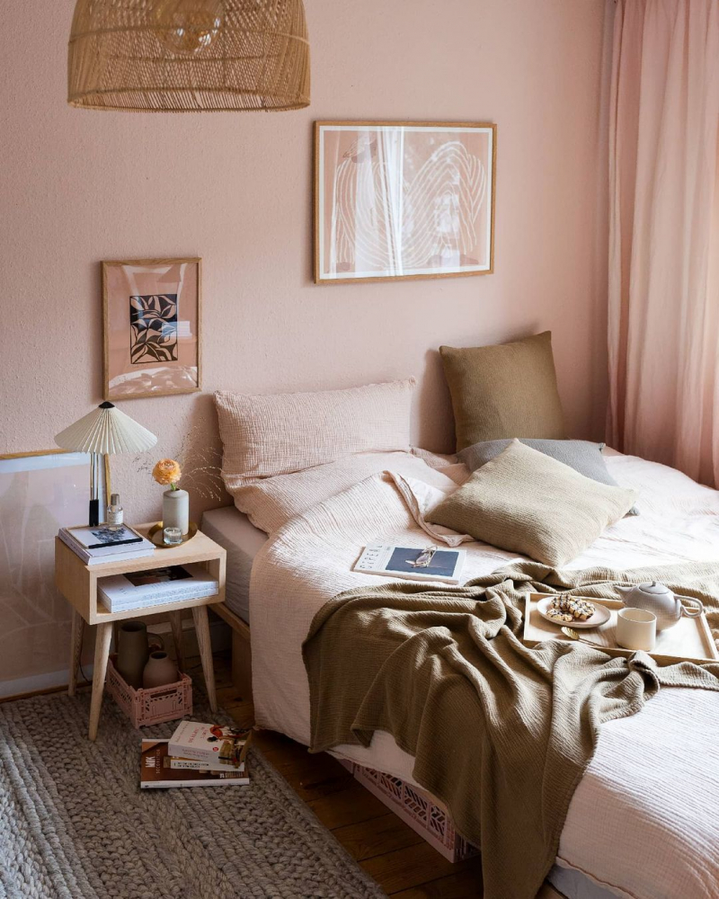 Bett mit rosa Bettwäsche und rosa Wandfarbe